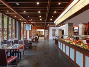 a restaurant with tables and chairs and a buffet at Grand Mercure Sanya Yalong Bay in Sanya