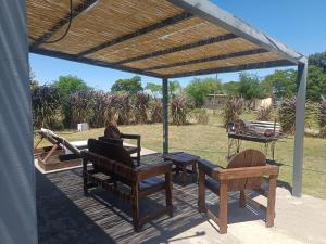 eine Holzterrasse mit Stühlen und einem Tisch und einem Grill in der Unterkunft Retiro San Francisco 2 hasta 6 huespedes -Pais Uruguay in Paysandú