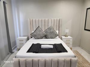 een slaapkamer met een groot bed met kussens bij Pado B & B in Gqeberha