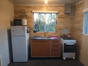 eine kleine Küche mit Spüle und Kühlschrank in der Unterkunft Retiro San Francisco 2 hasta 6 huespedes -Pais Uruguay in Paysandú