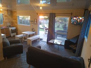 ein Wohnzimmer mit einer Couch, einem Fernseher und einem Tisch in der Unterkunft Retiro San Francisco 2 hasta 6 huespedes -Pais Uruguay in Paysandú