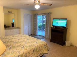 een slaapkamer met een bed en een flatscreen-tv bij Sea Cottage Apartment in Jekyll Island