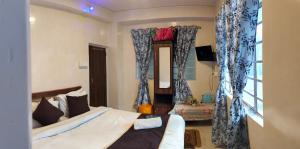 Schlafzimmer mit einem Bett mit blauen Vorhängen und einem Spiegel in der Unterkunft Rumdali Homestay NX in Darjeeling
