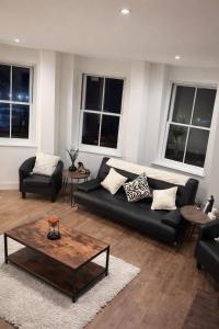 een woonkamer met een zwarte bank en een salontafel bij The Imperial Beachfront Penthouse Suite in Margate +8 foto's