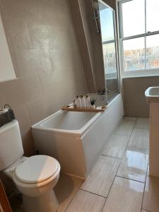 a bathroom with a tub and a toilet and a sink at The Imperial Beachfront Penthouse Suite in Margate +10 photos