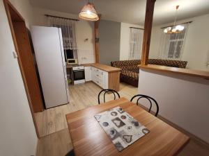 a kitchen and dining room with a table and a refrigerator at Apartmán Bára in Tanvald