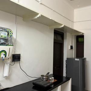 a kitchen with a black counter and a refrigerator at Ekantham Heritage Homestay in Tiruchirappalli