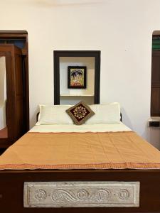 a bedroom with a large bed with a brown comforter at Ekantham Heritage Homestay in Tiruchirappalli