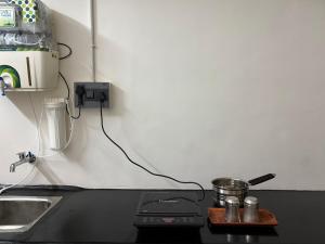 a kitchen counter with a stove with a pot on it at Ekantham Heritage Homestay in Tiruchirappalli