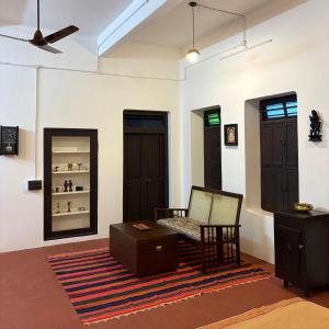 a living room with a chair and a mirror at Ekantham Heritage Homestay in Tiruchirappalli