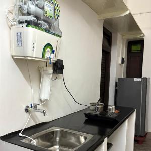 a kitchen with a sink and a machine on the wall at Ekantham Heritage Homestay in Tiruchirappalli +8 photos