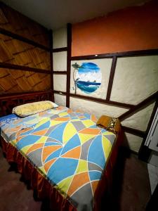 een bed in een kamer met een schilderij aan de muur bij CasaYaja in Ayampe