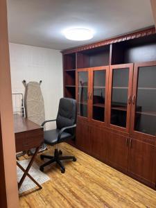 an office with a chair and a desk and cabinets at Квартира in Chişinău