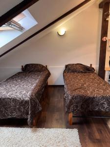 two beds in a room with a attic at Квартира in Chişinău
