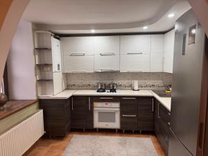a kitchen with white cabinets and a stove top oven at Квартира in Chişinău