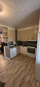 a kitchen with white cabinets and wooden floors at Villa Kjell in Vidsel