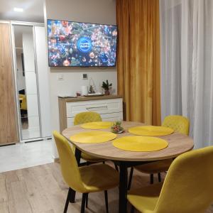 een eetkamer met een tafel en gele stoelen bij Apartament ZłotogórSKI Lądek-Zdrój in Lądek-Zdrój