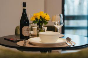 a table with a bottle of wine and yellow flowers at Nature Nest Noszvaj in Noszvaj
