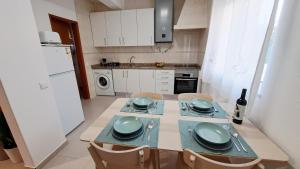 una cucina con tavolo, piatti e ciotole di Cosy Vau a Vau