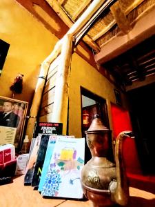 una mesa con libros y una lámpara. en Gite le Calme café Restaurant Pizzeria, en Bou Drarar