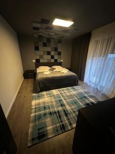 a bedroom with a bed and a rug on the floor at Vila Liana in Stana