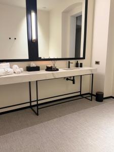 ein Badezimmer mit Waschbecken und großem Spiegel in der Unterkunft Sparano Palace - Luxury Maison in Bari