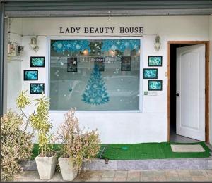 een etalage van een schoonheidssalon met een kerstboom bij Lady Beauty House in Lampang