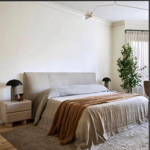 een witte slaapkamer met een groot bed en een deken bij Lady Beauty House in Lampang