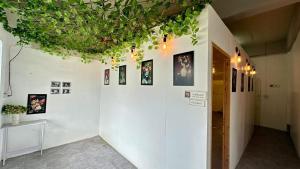een kamer met een witte muur met foto's erop bij Lady Beauty House in Lampang