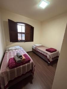 a bedroom with two beds and a window at Morada Alecrim in Diamantina +6 photos
