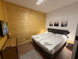a bedroom with a bed and a flat screen tv at Flora Hotel Apartment 103 in Borovets