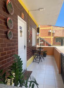 una casa in mattoni con una porta bianca e un tavolo di Porto dos Lençóis, Apartamento 05 a Barreirinhas