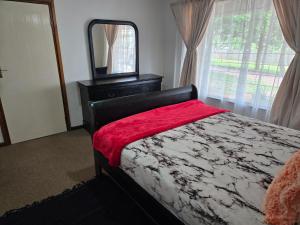 a bedroom with a bed with a mirror and a dresser at Hillcrest Cosy Cottage in Hillcrest