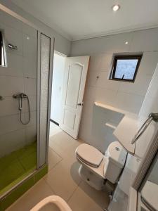 um banheiro com vaso sanitário, pia e chuveiro em La Quebrada lodge em Papudo