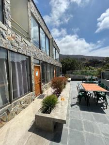 um pátio com uma mesa e cadeiras e um edifício em La Quebrada lodge em Papudo