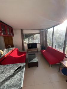 a living room with a red couch and a table at La Quebrada lodge in Papudo