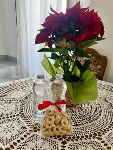 a table with a vase with a red flower and cookies at Centro Storico Di Tea in Turi