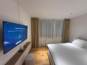 a bedroom with a bed and a flat screen tv at Prestige Lux Andan - Apart hotel Horizont Jahorina in Jahorina