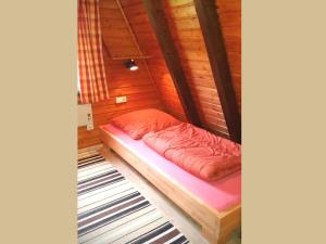 a small bed in a room with wooden walls at Charmantes Ferienhaus in Skigebietsnaehe in Schmallenberg