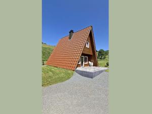 a small house with a pitched roof on a hill at Charmantes Ferienhaus in Skigebietsnaehe in Schmallenberg
