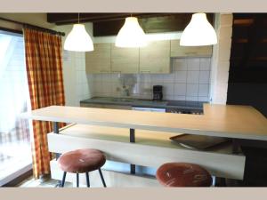 a kitchen with a table and two stools in it at Geraeumiges Apartment mit privater Terrasse in Schmallenberg +30 photos