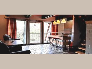 a living room with a table and chairs and a balcony at Geraeumiges Apartment mit privater Terrasse in Schmallenberg