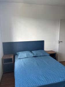 a bedroom with a bed with a blue comforter at Blue da Mantiqueira in Extrema