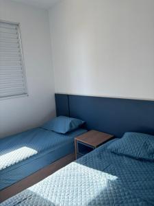 a bedroom with two beds and a table in it at Blue da Mantiqueira in Extrema