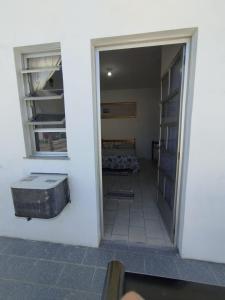 une chambre avec une porte ouverte et une chambre avec un lit dans l'établissement Suite Penha SC, à Penha