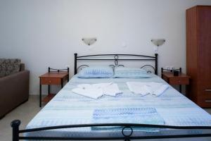 a bedroom with a bed with two towels on it at TO VOTSALO-beach side studios & taverna in Karpathos