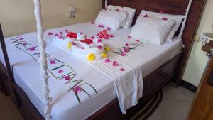 a bed with flowers on top of it at Kua Garden Bungalow in Utende