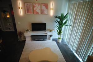 un soggiorno con TV e tavolo con piante di Charming 1 bed, 1 bath apartment a Cedar Park