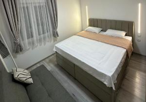 a small bedroom with a bed and a window at Apartman Posušje - Centar in Posušje