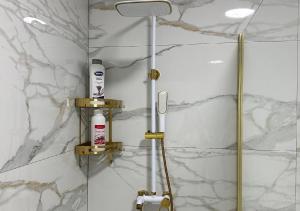 een douche in een badkamer met witte marmeren muren bij Centar Posušje Jednosobni stan in Posušje